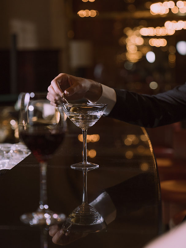 Mann in einer Bar vor sich ein Martini